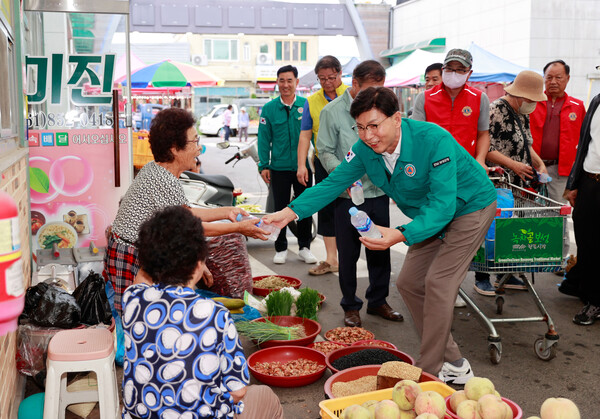 22일 무더운 폭염에 따른 온열질환을 예방하고자 녹차골보성향토시장에서 김철우 군수와 국제라이온스협회 355-b3지구 7지역(보성라이온스, 보성산양라이온스, 보성여성라이온스) 회원들이 상인들에게 시원한 생수와 부채를 전달하고 있다. [사진=보성군]