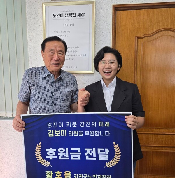 황호용 대한노인회 강진군지회장이 김보미 의원에게 후원금 전달 기념촬영을 하고 있다. [사진=강진군의회]