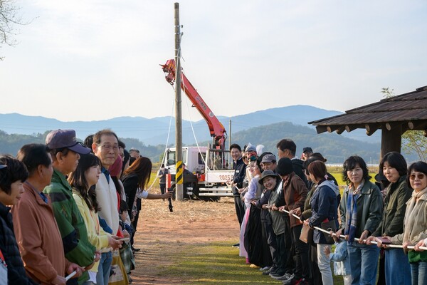 순천만 안풍들에서 참석자 전원이 전봇대 철거 줄다리기를 하고 있다. [사진=순천시]